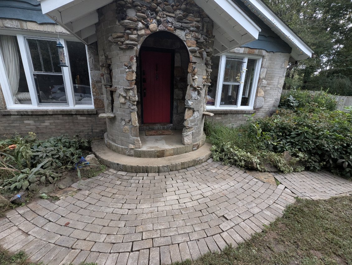 Stone porch, red door, brick walk.